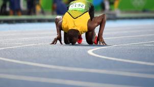 Usain Bolt embrasse la piste sur laquelle il a, peut-être, gagné son dernier 200 m. © AFP / Olivier Morin.