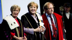La chancelière Angela Merkel entourée des recteurs de l’UGent, Anne De Paepe, et de la KUL, Rik Torfs, après la cérémonie. © Belga