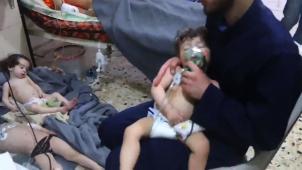 Des membres de la défense civile syrienne, munis de masques à oxygène, ont porté secours à des enfants à Douma.