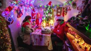 Dans son bureau éclairé de jolies couleurs pastel, le père Noël  répond patiemment aux lettres que les enfants ont postées à l’entrée du village de Serge.