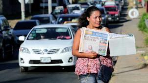 Une vendeuse de journaux avec la page blanche de «
La Prensa
», le 18 janvier à Managua. En bas de la «
Une
», cette simple interrogation
: «
Vous êtes-vous déjà imaginé vivre sans information
?
»