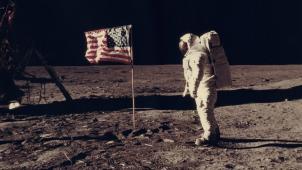 Apollo 11: L’astronaute Edwin E. Aldrin, pilote de module lunaire de la première expédition d’atterrissage sur la lune, pose pour un photographe à côté du drapeau des États-Unis déployé pendant une activité extra-véhiculaire (EVA) sur la surface lunaire.