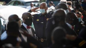Un policier salue au passage du cercueil lors des funérailles de George Floyd ce mardi à Houston. © AFP/Mark Felix.