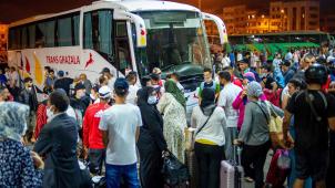 Casablanca, dimanche soir
: des Marocains tentent à la dernière minute de trouver une place dans un bus qui les conduirait vers leurs proches pour la fête de l’Aïd.
© Rizkou ABDELMJID/AFP.
