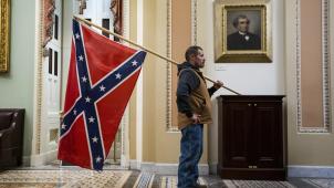 Parmi les innombrables images édifiantes diffusées en boucle, il en est une particulièrement chargée de symboles: celle de ce manifestant déambulant tranquillement dans les couloirs du Capitole le drapeau confédéré posé sur l’épaule.