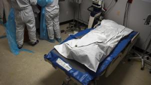 Un patient décédé gît dans un sac mortuaire à l