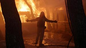 Un pompier face à un mur de feu à Varympompi, une petite ville à une trentaine de kilomètres de la capitale grecque, d’où est parti l’incendie.