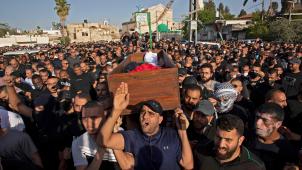 Mousa Hassouna, Israélien palestinien de la ville de Lod, est emmené par la foule au cimetière le 11 mai, le cercueil recouvert d’un drapeau palestinien.