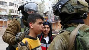 Les forces de sécurité israéliennes arrêtent un garçon palestinien. Des affrontements entre la population majoritaire palestinienne et les colons juifs à Hébron éclatent souvent après la prière du vendredi en raison de la présence massive d