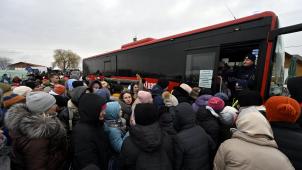Des réfugiés ukrainiens embarquent à bord de bus au poste frontière de Medika en Pologne.