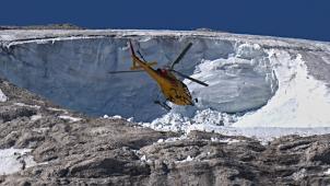 Un hélicoptère de sauvetage survole le glacier Punta Rocca qui s