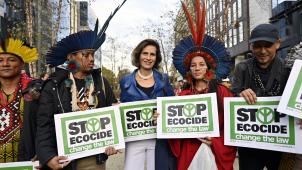 La princesse Esmeralda manifeste pendant le sommet européen en compagnie du réalisateur Gert-Peter Bruch (à droite) et de représentants de la forêt amazonienne en tenue traditionnelle.