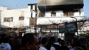 Des Palestiniens sont rassemblés devant une habitation touchée par les tirs israéliens.