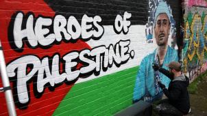 Un graffeur, à Londres, en train de créer une image de street art du Dr Ahmed Moghrabi, chirurgien à l’hôpital Nasser de Khan Younis, dans le sud de la bande de Gaza.