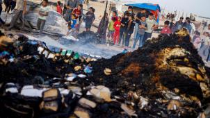 Des enfants cherchent de la nourriture dans les débris brûlés dues aux attaques israéliennes.