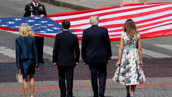 Les deux couples présidentiels se sont tenus devant le drapeau américain à la fin du défilé militaire qui se déroulait aux Champs-Elysées. © AFP