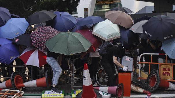 Toujours à Hong-Kong, des manifestants font barrage avec des parapluies. Les manifestations, parfois violentes, continuent.