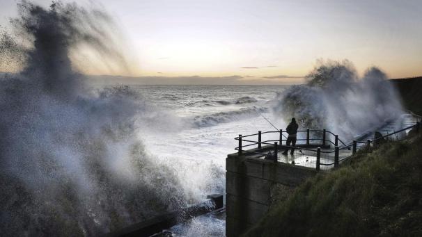 À Seaham, au Nord de l’Angleterre, un pêcheur attend sa proie face aux vagues qui s’abattent sur la côte.