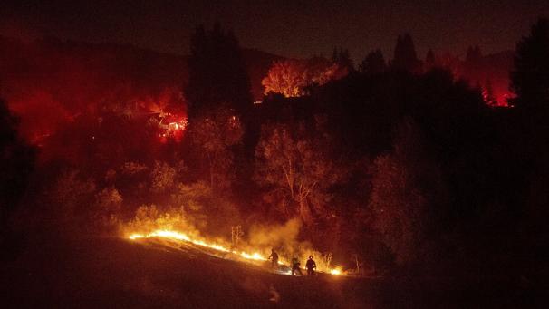 Les pompiers travaillent à contenir un incendie qui brûle au large de Merrill Dr. à Moraga en Californie. La police a ordonné des évacuations alors que l’incendie se propageait dans les collines de la communauté de la baie de San Francisco.