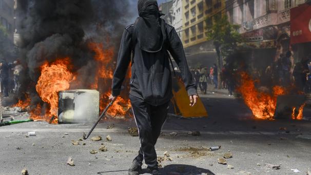 Un manifestant anti-gouvernement se tient devant une barricade en feu à Valparaiso, au Chili. Le président Sebastian Pinera tente de stopper les protestations violentes survenues après l
