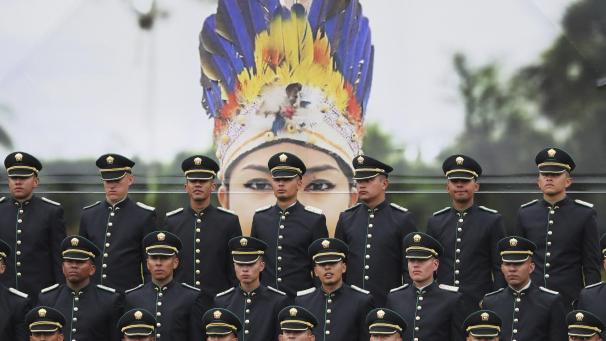 Des cadets de la police nouvellement diplômés se tiennent en formation devant une grande photographie d’un policier autochtone, lors de leur cérémonie de remise des diplômes à Bogota, en Colombie.
