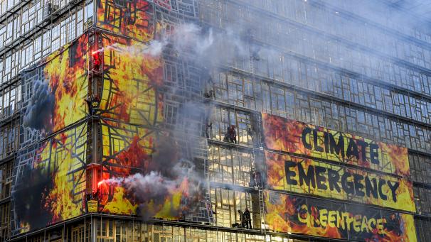 Plus de 60 militants de Greenpeace ont grimpé sur la façade du bâtiment Europa, qui accueille le Conseil européen, pour y déployer des bannières géantes. Le but: montrer que «notre maison est en feu. Il est maintenant temps pour une politique climatique décisive».
