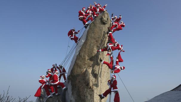 Des alpinistes en tenue de Père Noël posent lors d’un événement visant à faire la promotion de l’escalade sécuritaire et à promouvoir la charité de Noël à Séoul en Corée du Sud.
