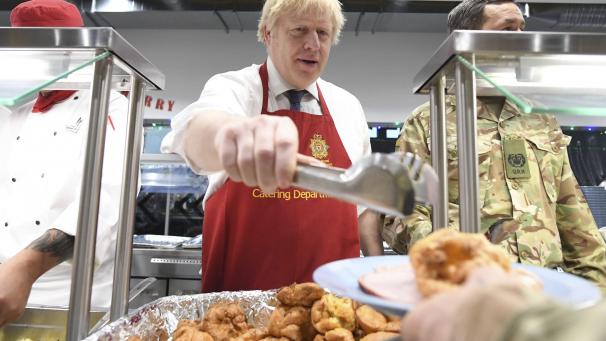 Le Premier ministre britannique Boris Johnson sert le déjeuner de Noël aux troupes britanniques stationnées en Estonie lors d’une visite d’une journée dans le pays balte, à Tallinn.