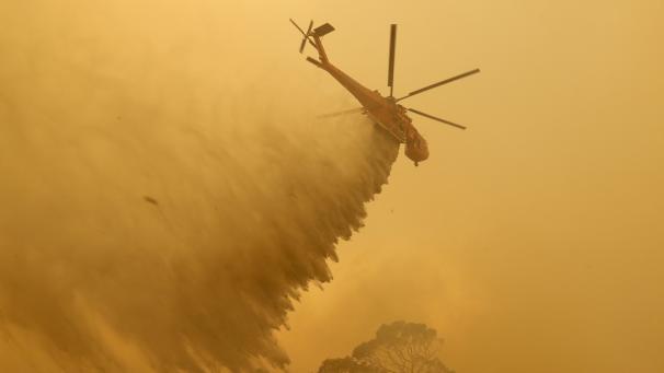 Un hélicoptère déverse de l’eau sur un incendie près de Bumbalong, au sud de la capitale australienne, Canberra.