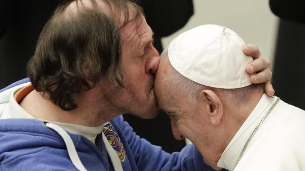 Un homme embrasse le pape François lors d’une audience au Vatican.
