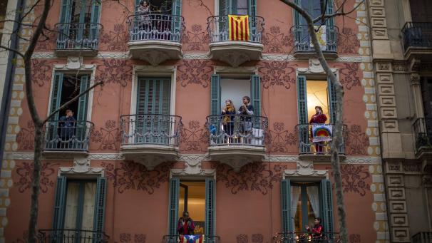 Les gens applaudissent de chez eux pour marquer leur soutien au personnel médical durant l’épidémie de coronavirus à Barcelone, en Espagne.