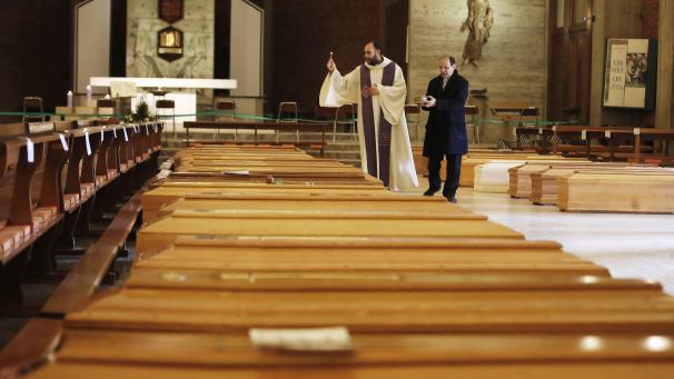 Un prêtre bénit les cercueils de victimes du coronavirus dans l’église San Giuseppe à Seriate en Italie.