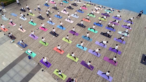 Un groupe de femmes pratiquant le yoga dans un parc local pour célébrer la Journée internationale du yoga et promouvoir le yoga, dans la province de Jiangsu, dans l’est de la Chine.