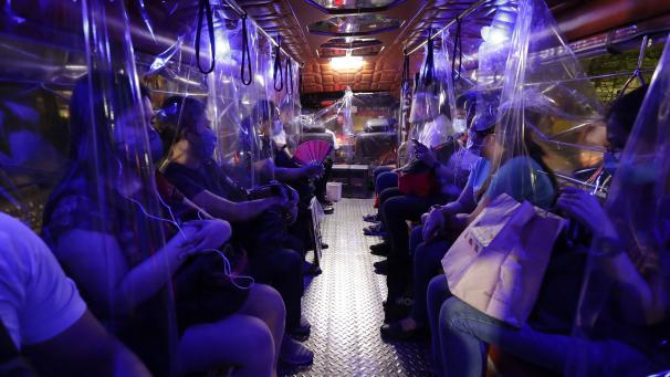 Des feuilles de plastique dans un autobus Jeepney séparent les passagers dans le cadre de mesures de santé visant à prévenir la propagation du coronavirus dans la métropole de Manille, aux Philippines.