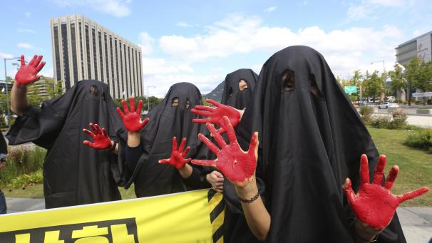 Des activistes montrent la terre qui brûle lors d’une manifestation à Séoul, en Corée du Sud.