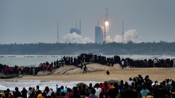 Des gens regardent une fusée décoller du Centre de lancement spatial Wenchang dans la province de Hainan, dans le sud de la Chine.