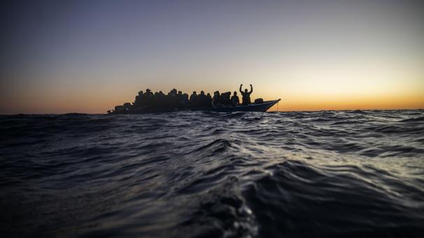 Des migrants et réfugiés de différentes nationalités africaines attendent une assistance sur un bateau en caoutchouc surpeuplé au large des côtes libyennes.