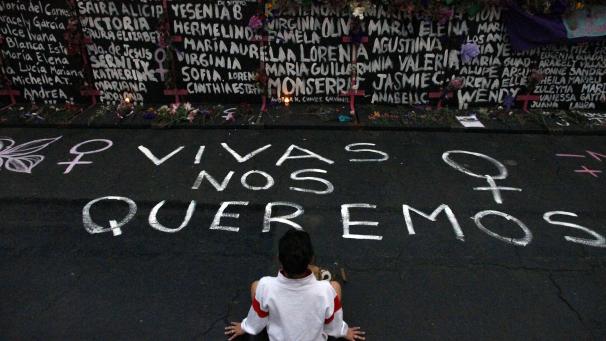 Au Mexique, une femme se tient devant un mur recouvert de noms de femmes victimes de féminicide lors d’une manifestation pour la lutte des droits des femmes.