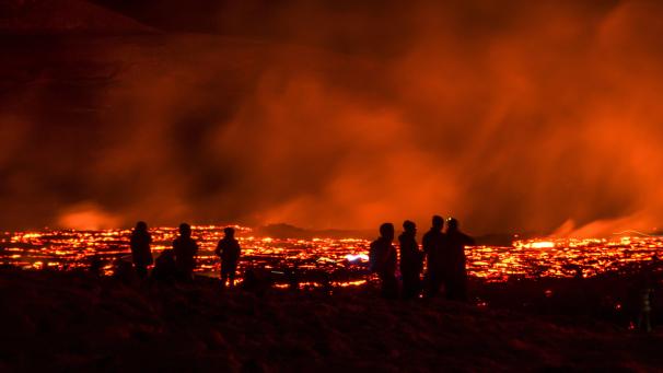Les gens observent les coulées de lave provenant d’une éruption d’un volcan sur la péninsule de Reykjanes, dans le sud-ouest de l’Islande.