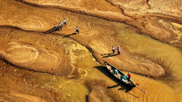 Des villageois transportent de l’eau à travers les bancs de sable de Pakokku en Birmanie.