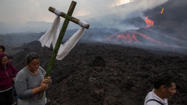 Une femme porte une croix de bois lors d’un pèlerinage pour prier pour que le volcan Pacaya diminue son activité, à San Vicente Pacaya, au Guatemala.