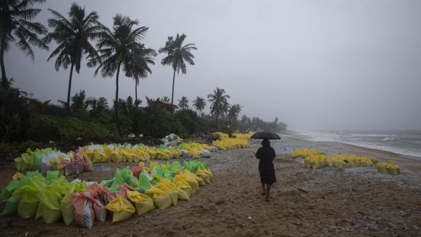 Les granulés de plastique qui ont été rejetés à terre, provenant du porte-conteneurs endommagé par le feu MV X-Press Pearl, sont recueillis par les officiers de la marine et conservés dans des sacs sur la plage de Kapungoda, à la périphérie de Colombo, au Sri Lanka.
