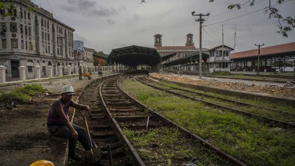 Un travailleur fait une pause sur les rails de la gare centrale, à La Havane (Cuba). La gare, monument historique national à quatre étages datant de 1910, est en cours de restauration.