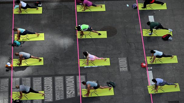 Des New-Yorkais participent au « Mind Over Madness Yoga » pour célébrer le solstice d’été à Times Square.