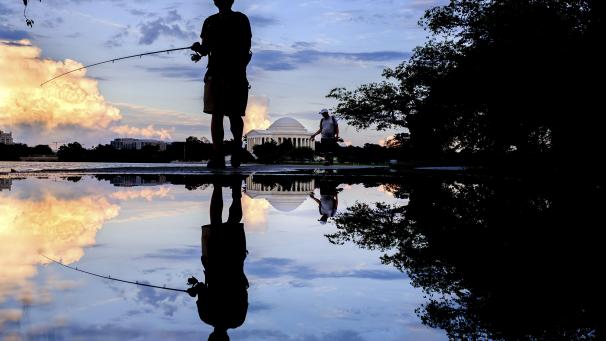 Des pêcheurs se reflètent dans les flaques d’eau près du Jefferson Memorial après de fortes pluies survenues à Washington.