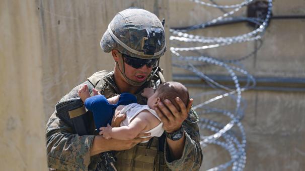Un marine des États-Unis réconforte un nourrisson pendant une évacuation à l’aéroport international de Kaboul, en Afghanistan.