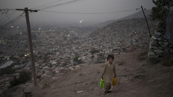 Un garçon transporte de l’eau jusqu’à sa maison au sommet d’une colline à Kaboul, en Afghanistan.