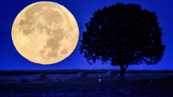 La pleine lune se couche derrière les collines de la région de Taunus, en Allemagne.