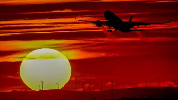 Un avion décolle à l’aéroport international de Francfort, en Allemagne, alors que le soleil se couche.