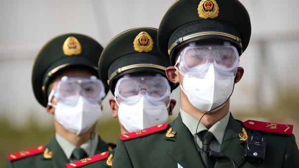 La police paramilitaire chinoise défile en portant des lunettes et des masques à Beijing.